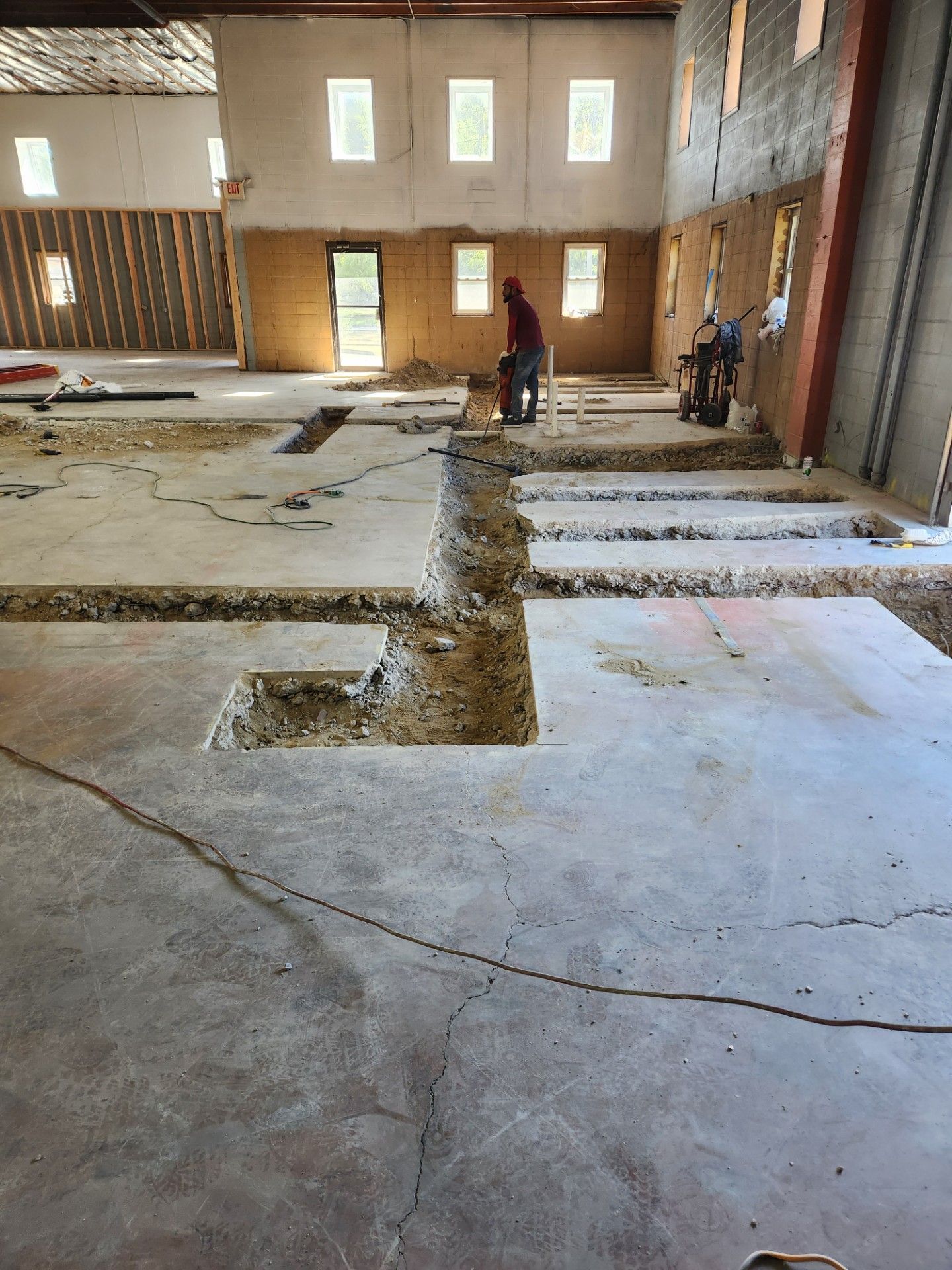 A man is working on the floor of a building under construction.