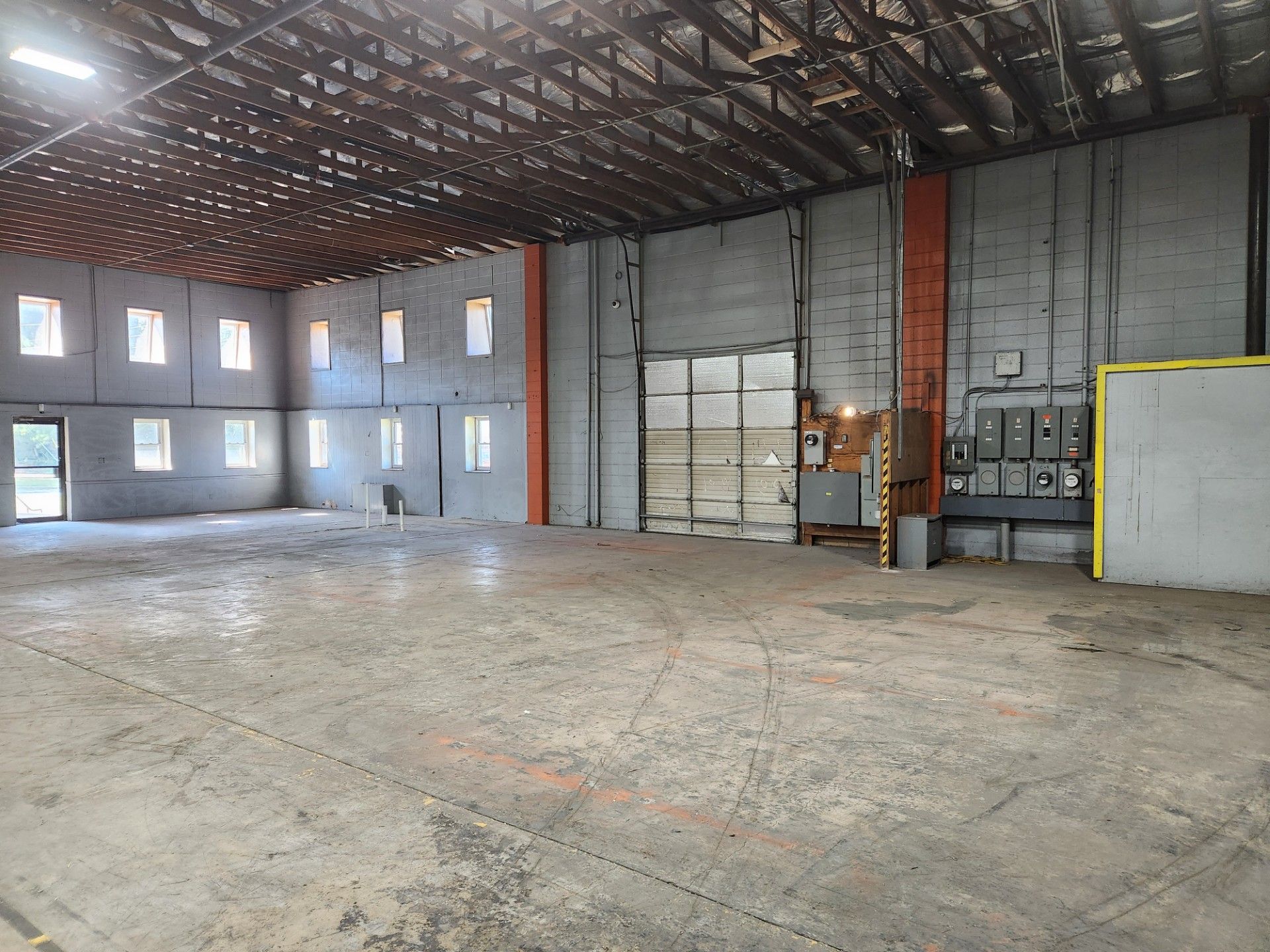 An empty warehouse with a lot of windows and doors