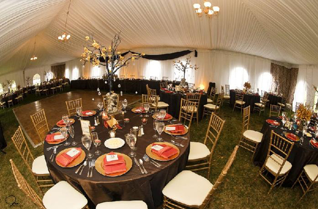 Table and chairs inside a wedding tent