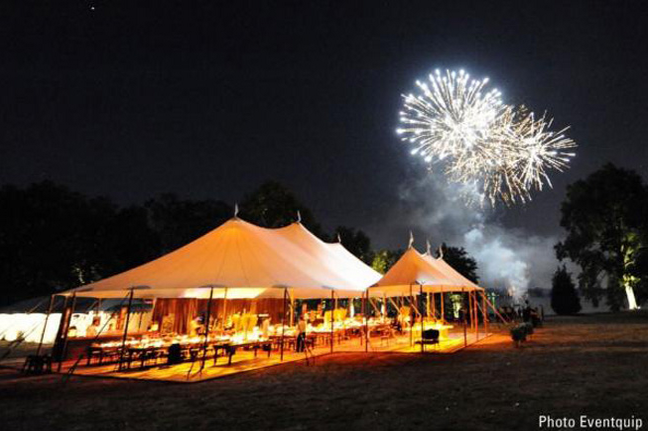 White tent with fireworks in the background