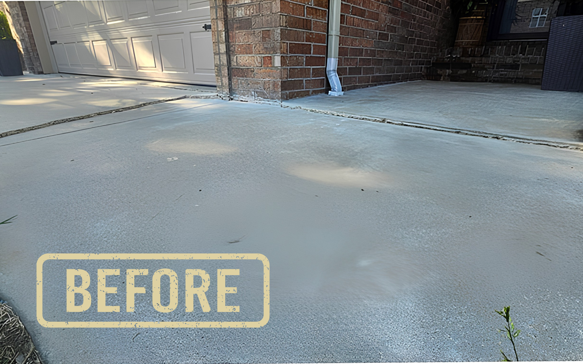 Concrete driveway beside a brick wall and garage