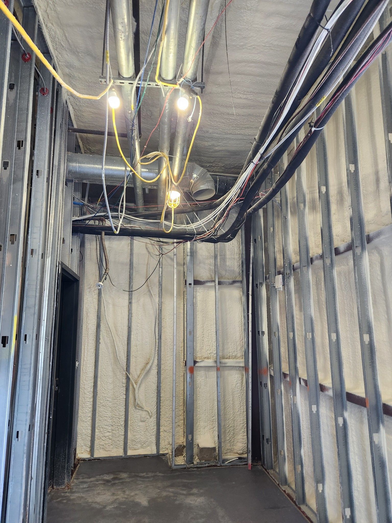 Exposed electrical wiring in an unfinished basement or utility room with insulated walls.