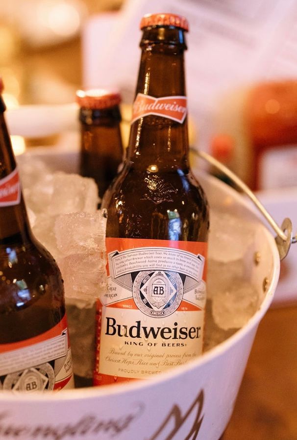 Budweiser beer bottles in an ice bucket, with orange and white labels.