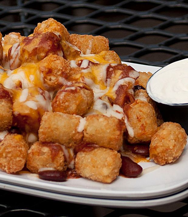Tater tots topped with chili, melted cheese, and a side of sour cream.