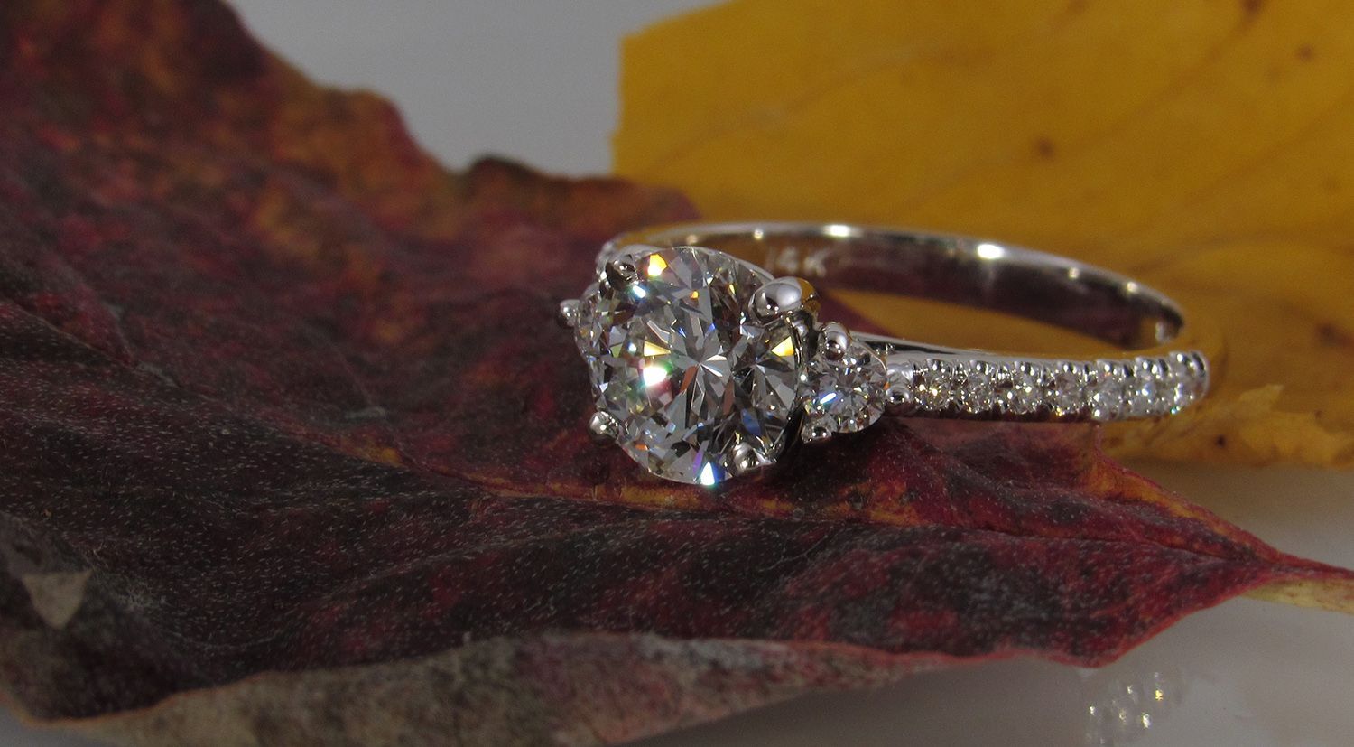 A diamond ring is sitting on top of a leaf