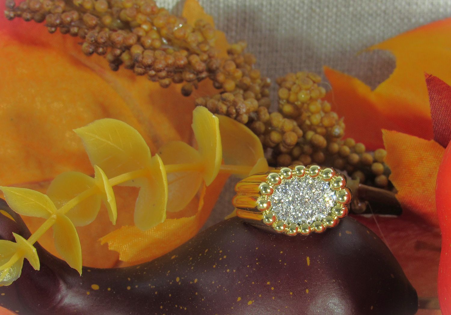 A close up of a ring surrounded by flowers and leaves