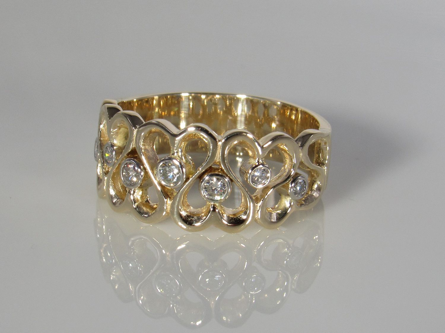 A gold ring with hearts and diamonds on it