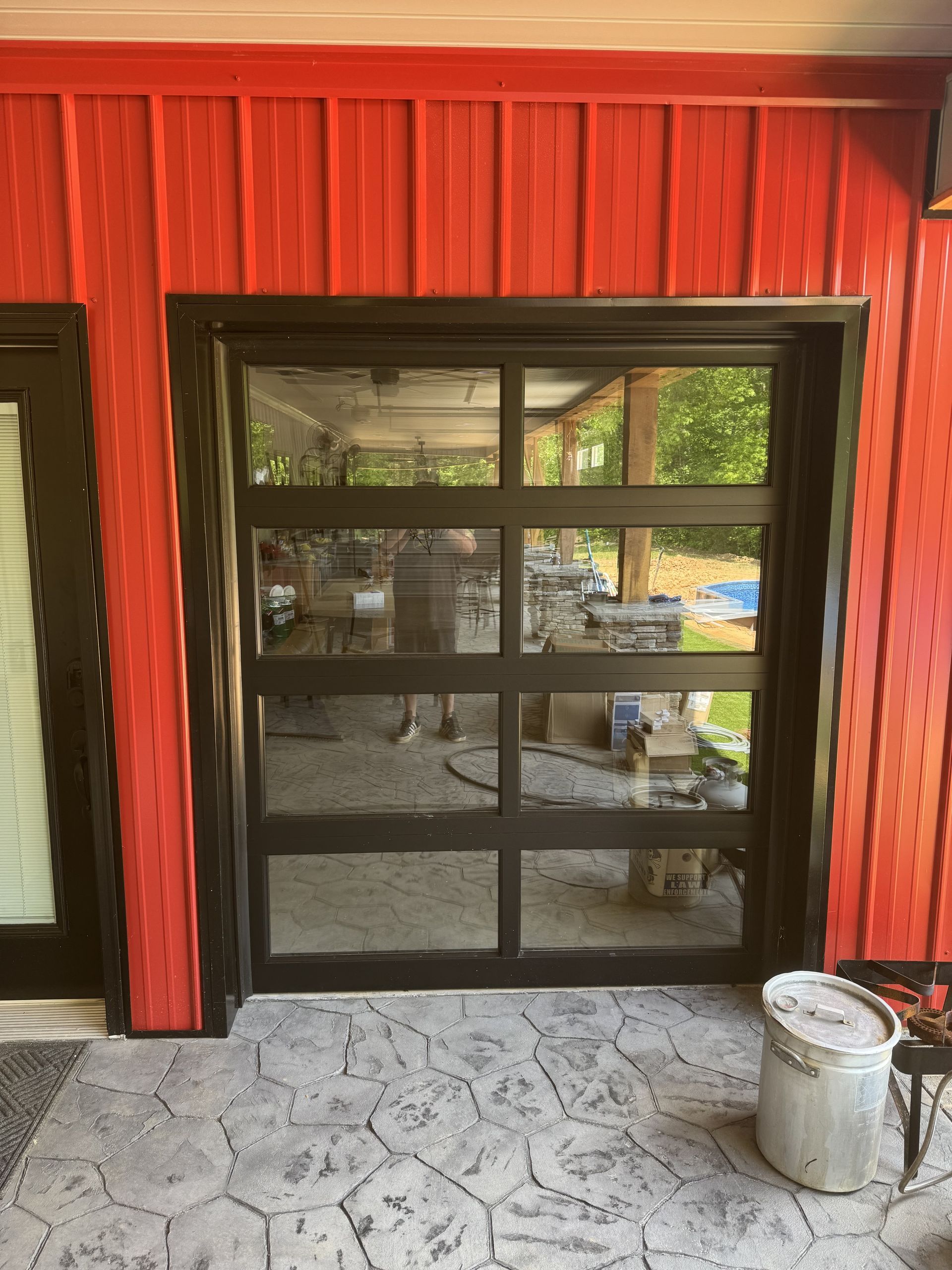 Glass paneled door with black frame on red exterior.