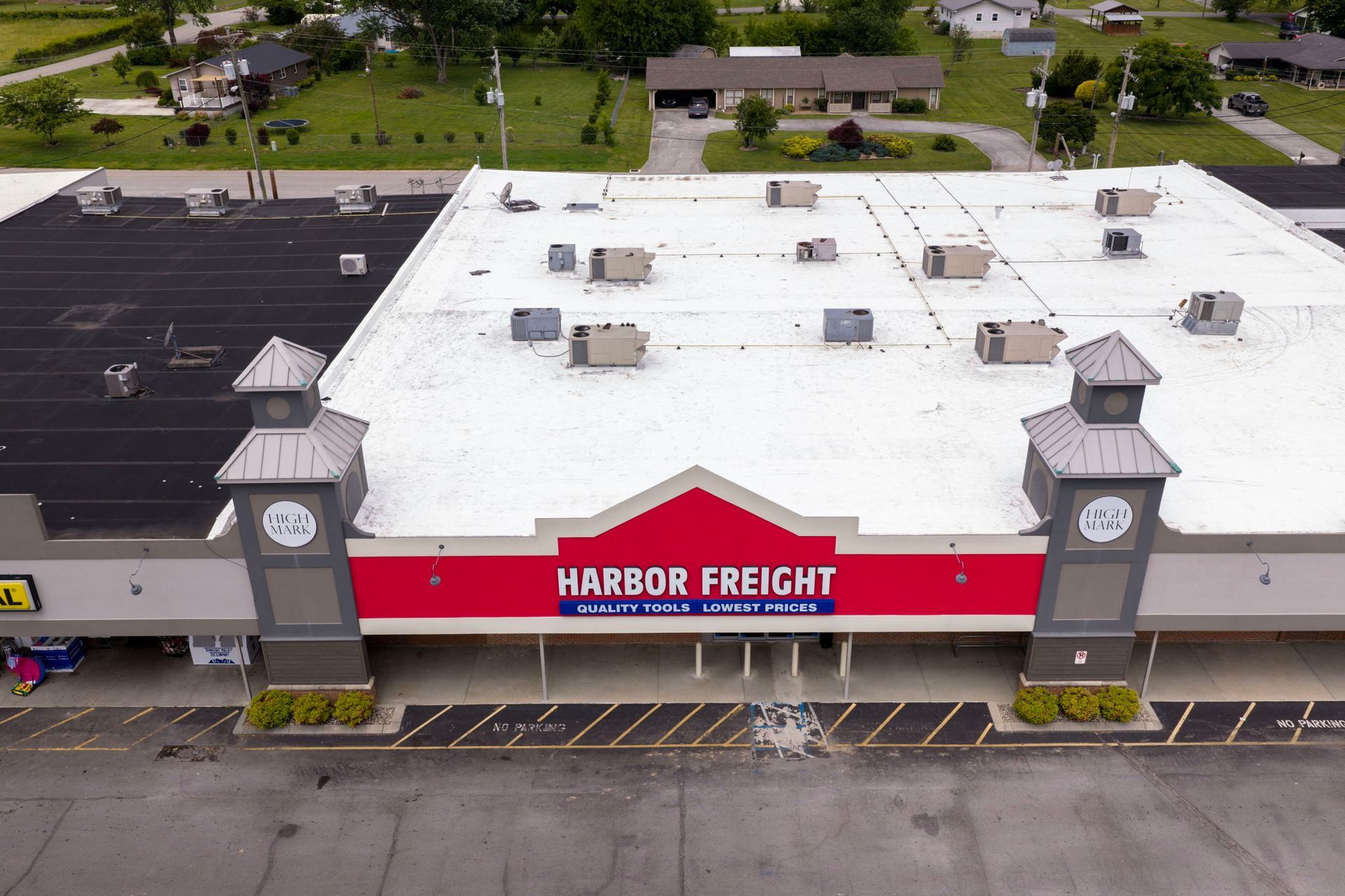 Aerial view of Harbor Freight store with white roof and red storefront sign
