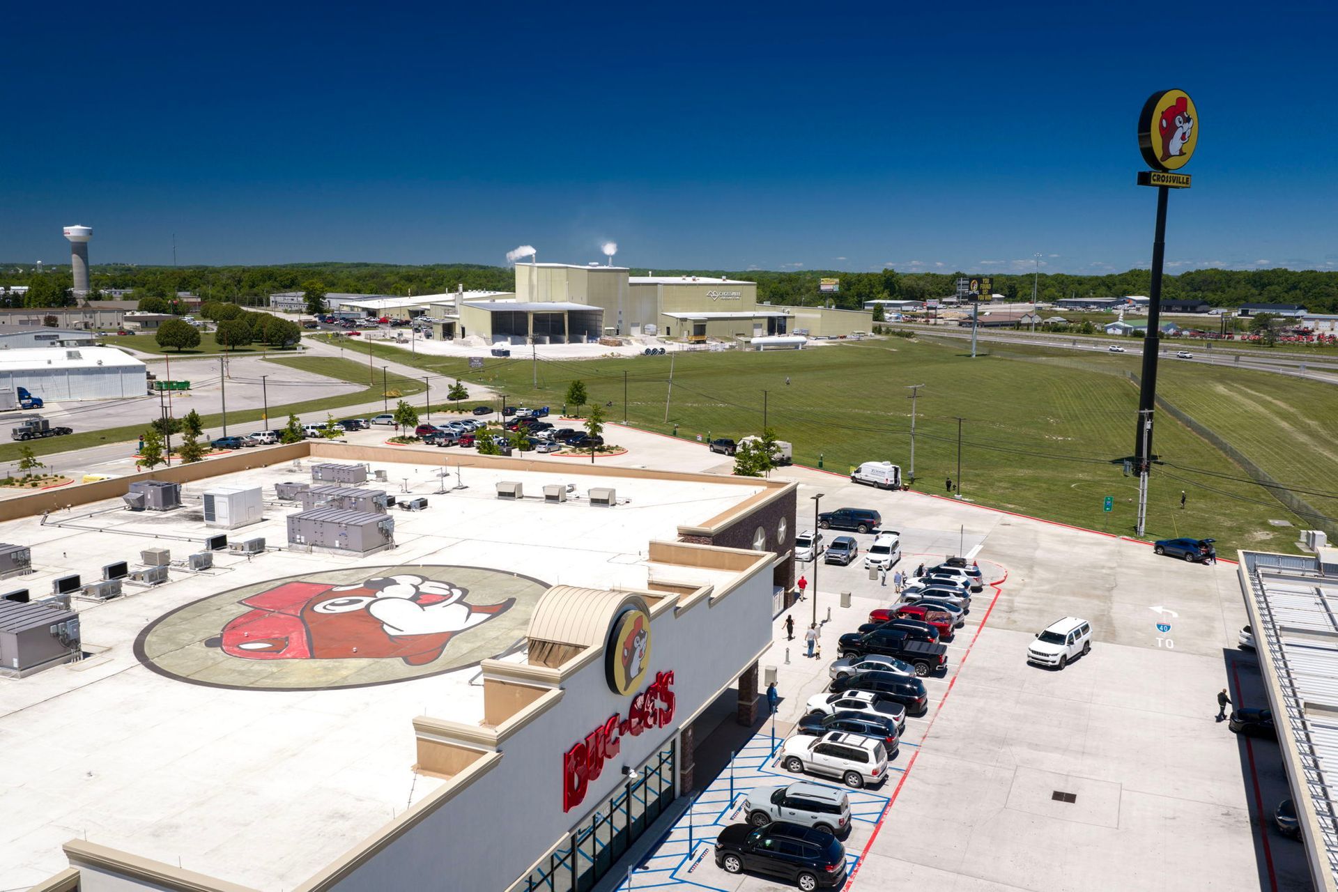 Aerial view of a Burger King and parking lot beside a highway under a clear blue sky