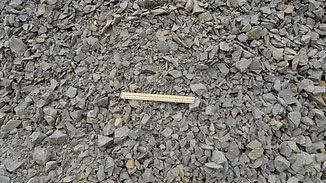 Pale wooden stick lying on gray gravel stones