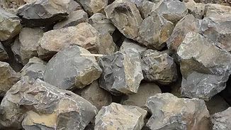 Pile of gray and tan rocks stacked together outdoors