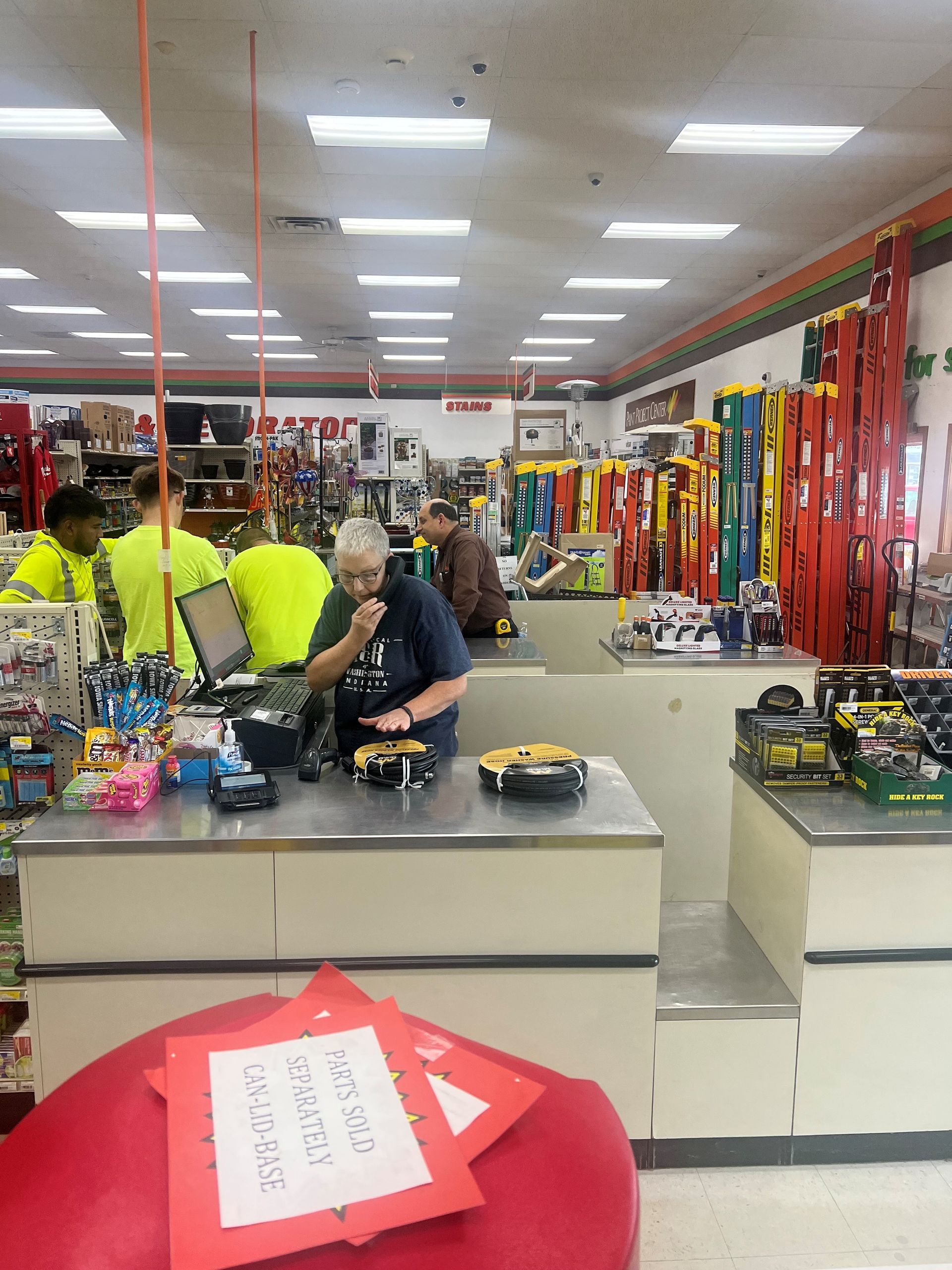 A man standing at a counter in a store with a sign that says pay here