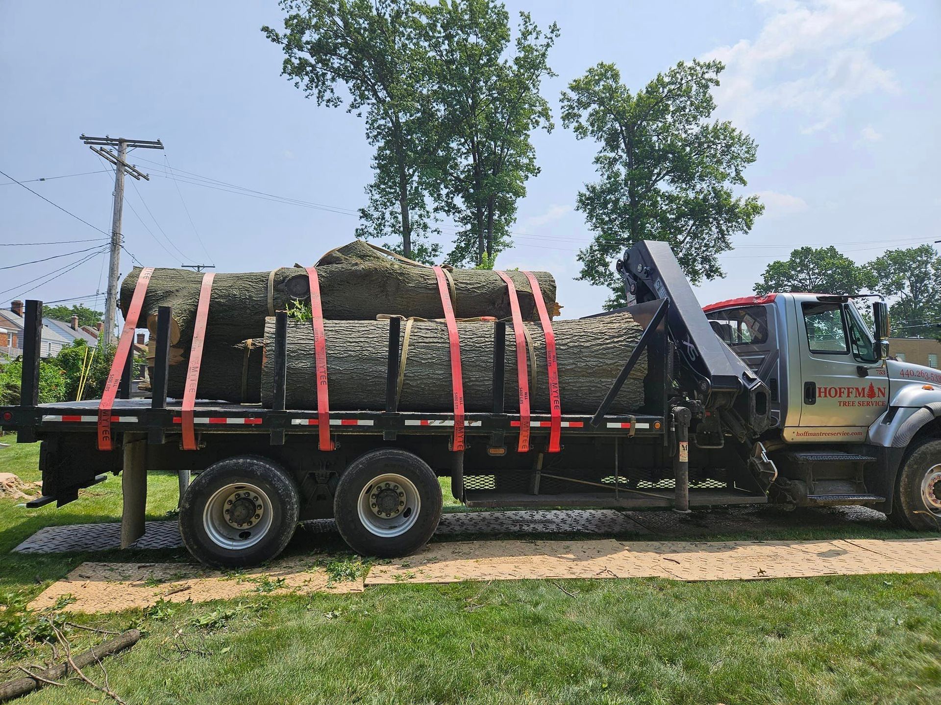 A large log is sitting on the back of a truck.