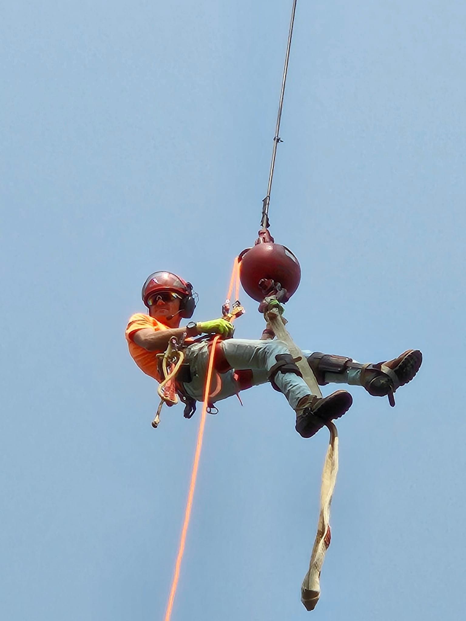 A man is hanging from a rope in the air