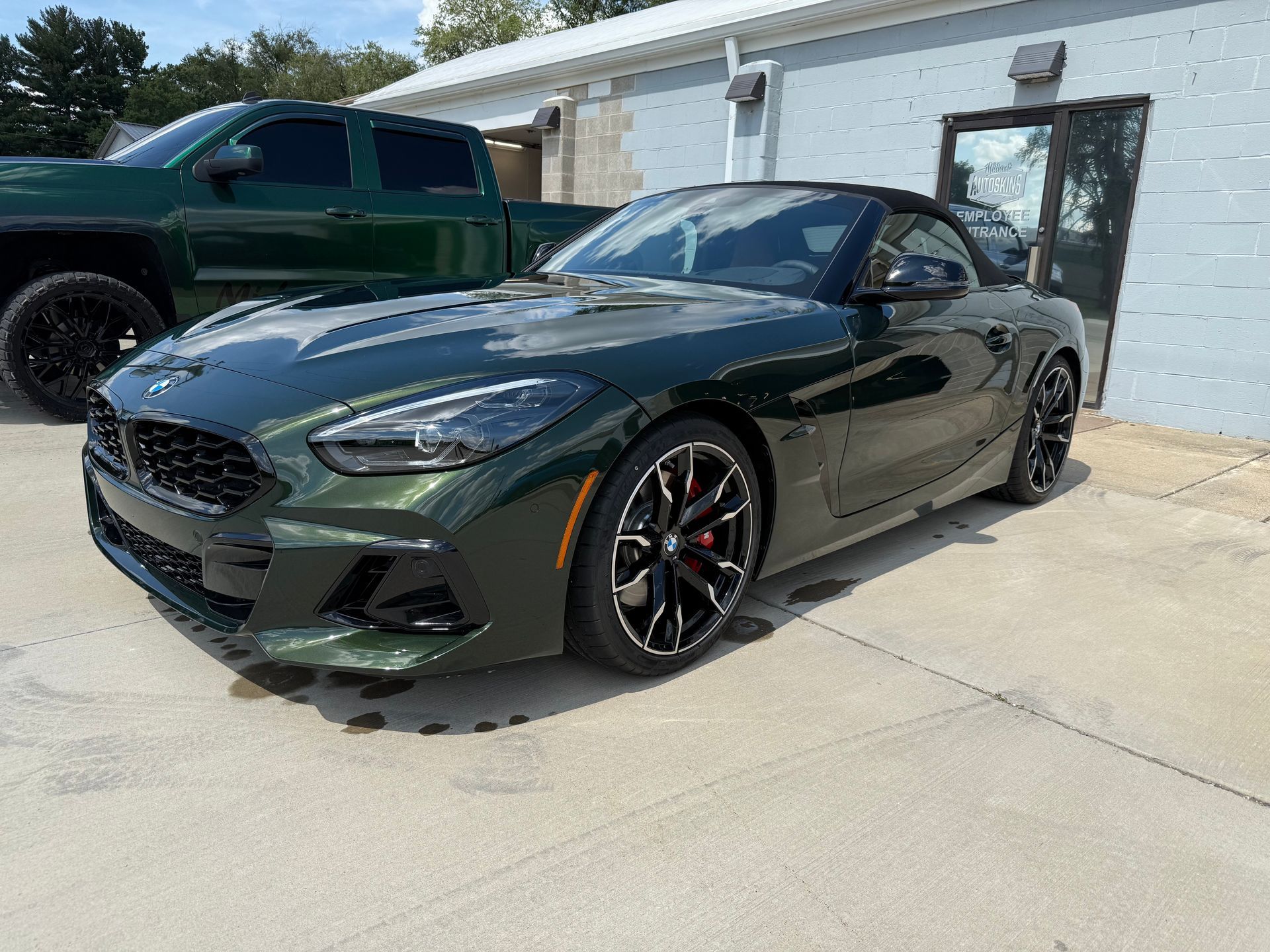 Black Corvette sports car in a garage with black rims and red brake calipers.