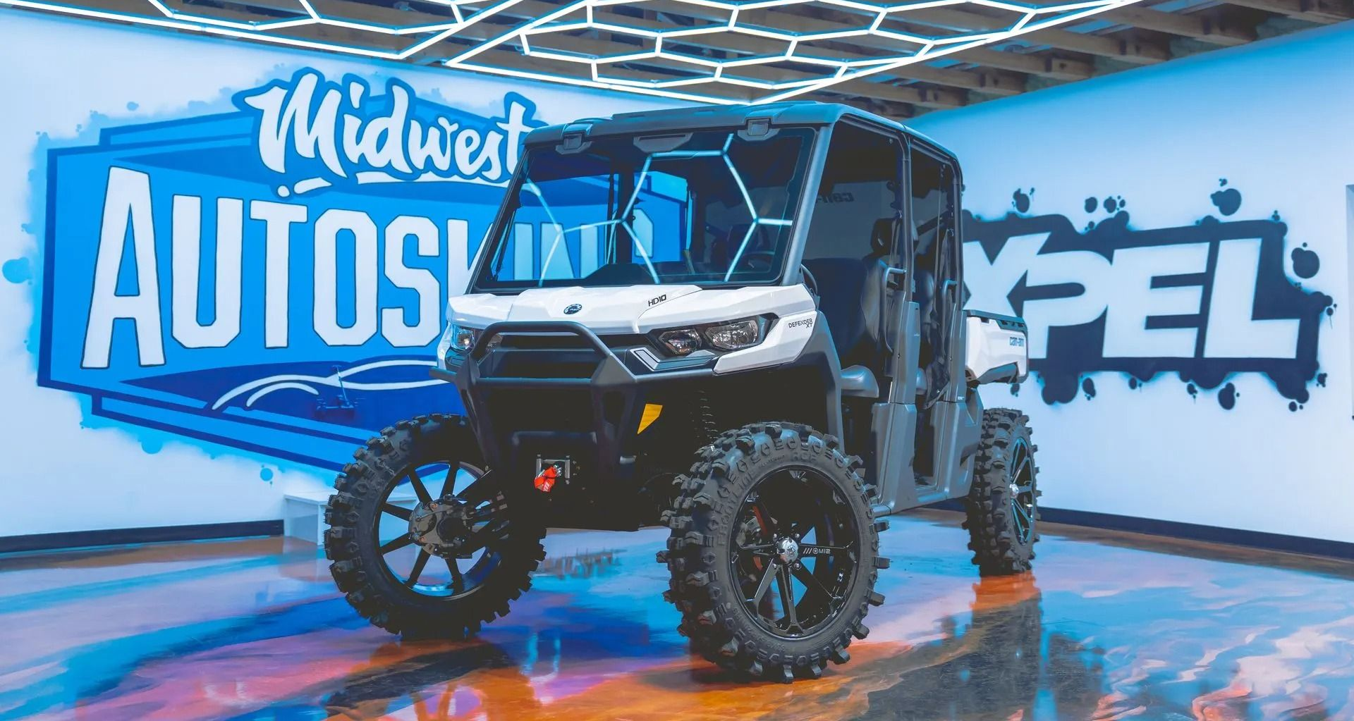 Side-by-side ATV with custom wheels parked at Midwest Autoshow.