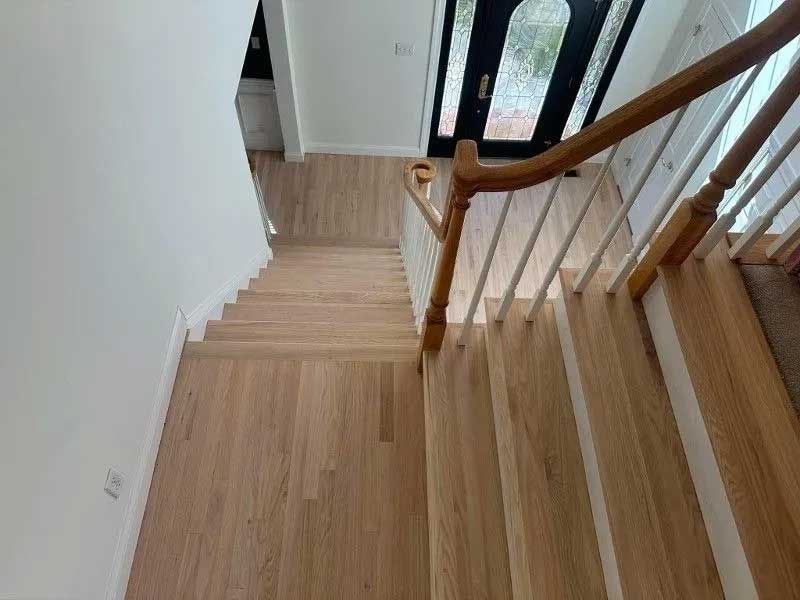 Wooden staircase leading down from a door with glass panels.
