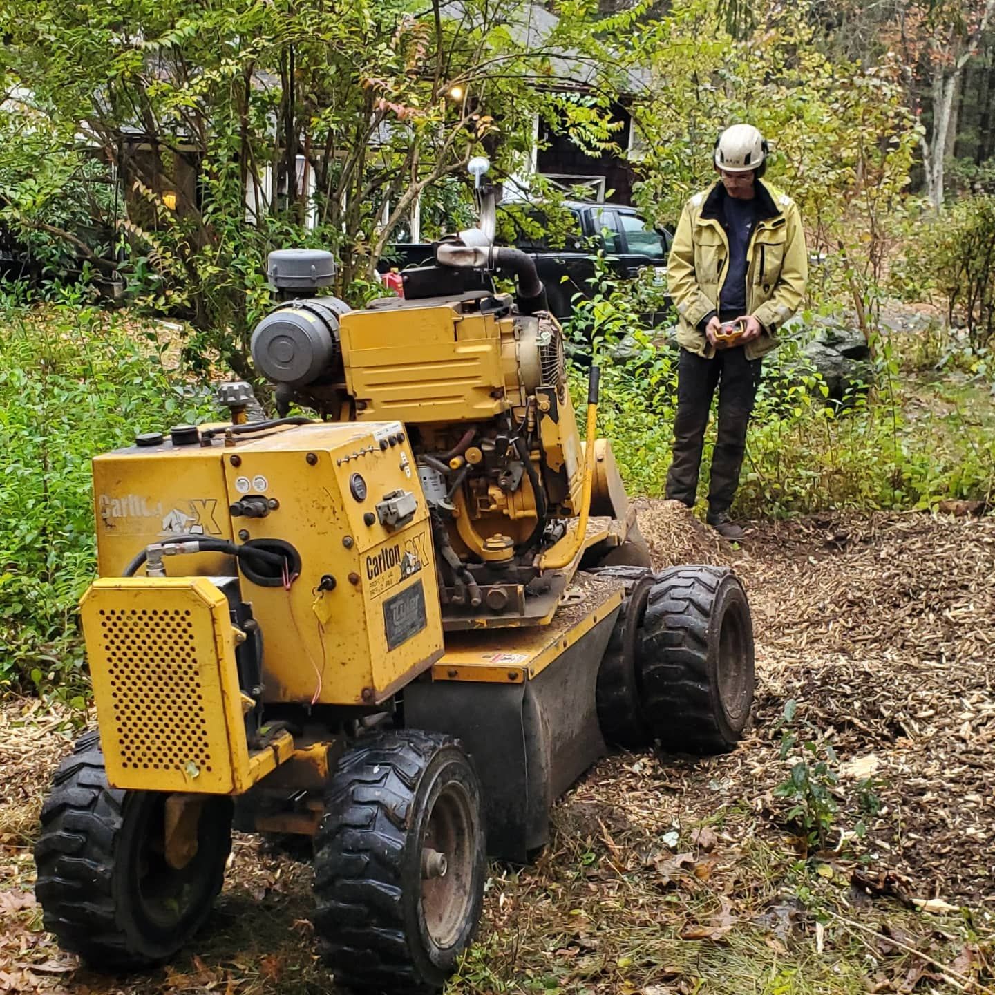 A man standing next to a yellow tractor in a field