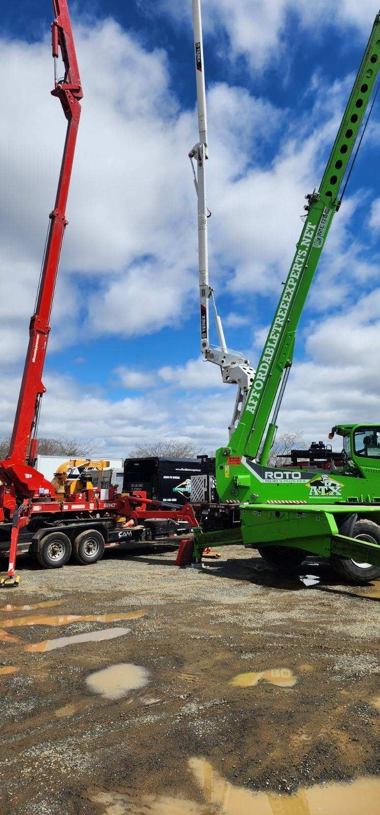 Two concrete pumps are sitting next to each other in a parking lot.
