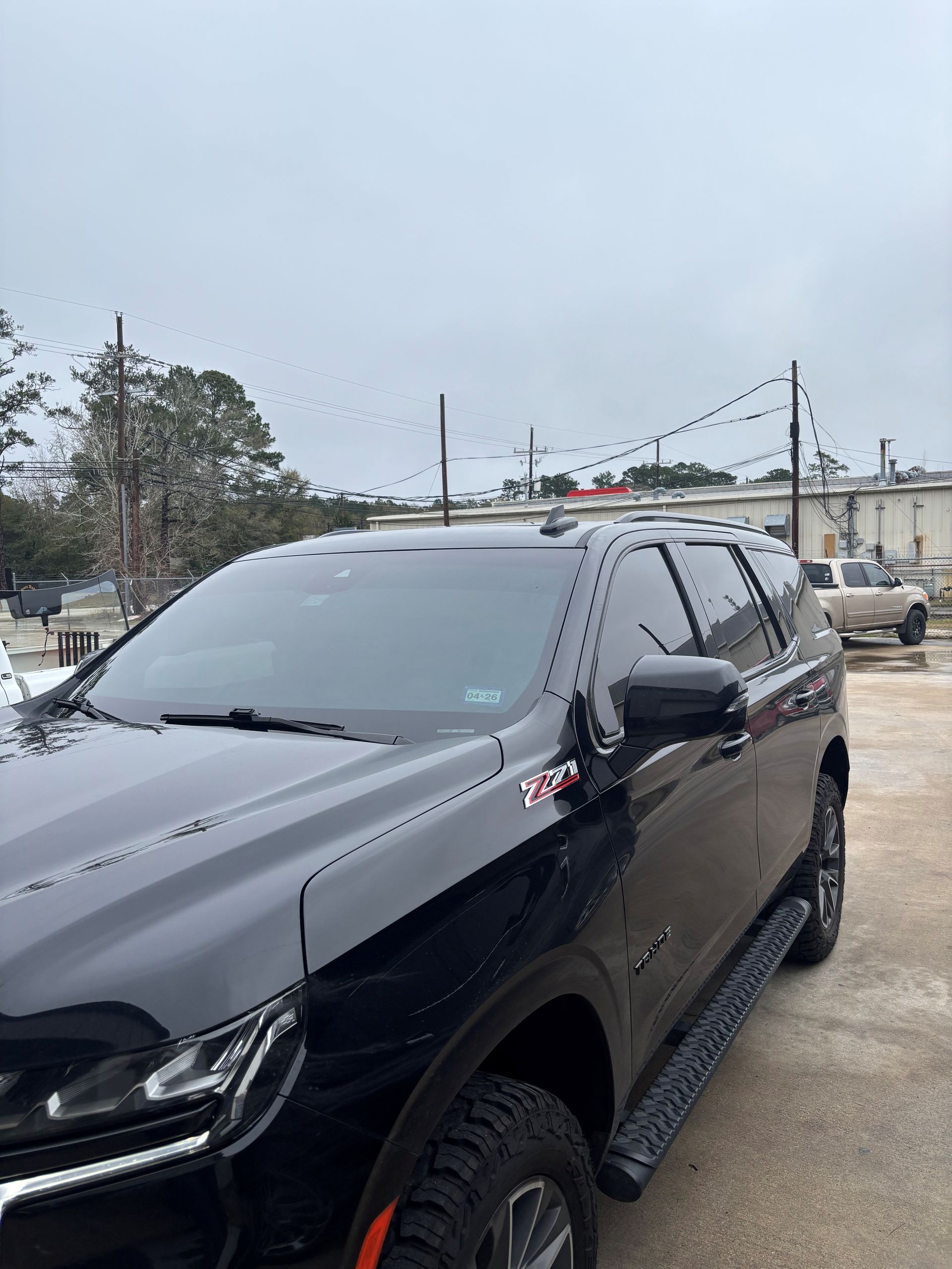 A black Chevrolet Suburban Z71 parked outdoors on an overcast day.
