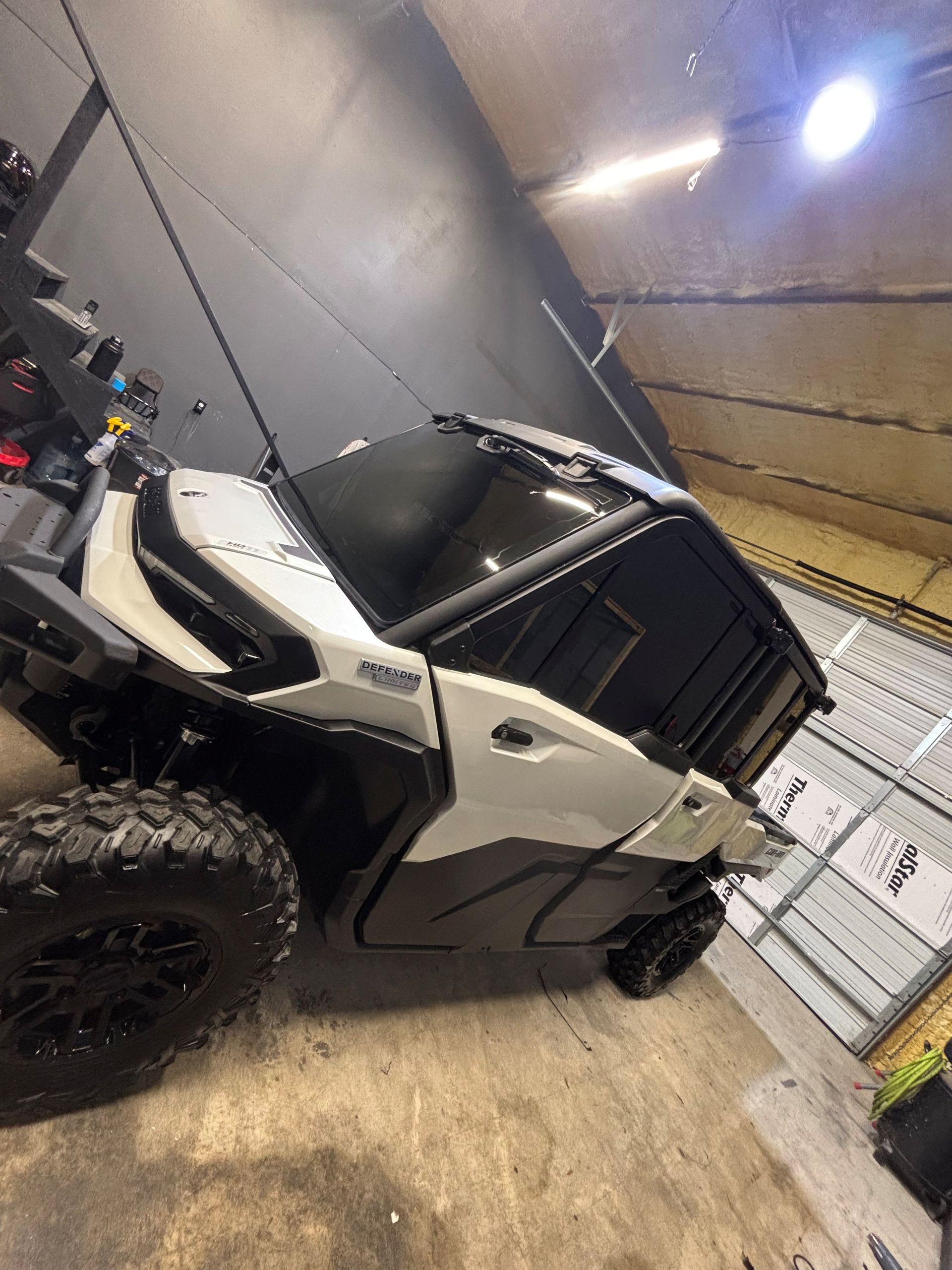 White and black off-road utility vehicle parked inside a garage.