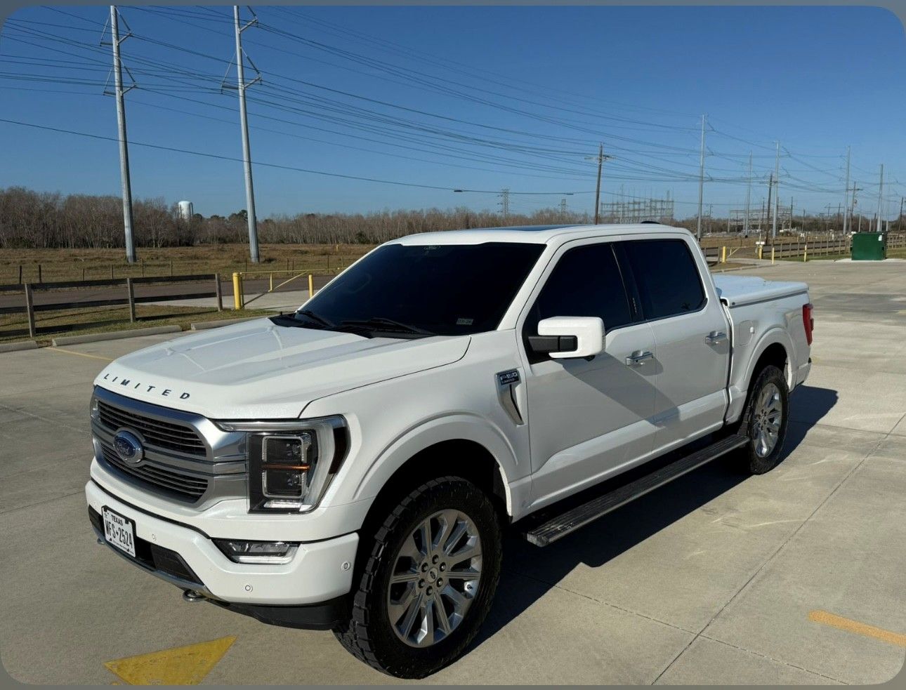 A white Ford F-150 Limited pickup truck parked in an outdoor lot on a sunny day.