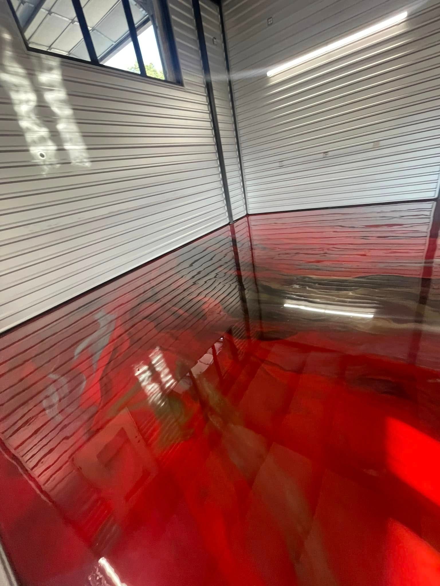 Red-floored, white-walled interior with a shiny, reflective surface. Sunlight streams in from the ceiling.
