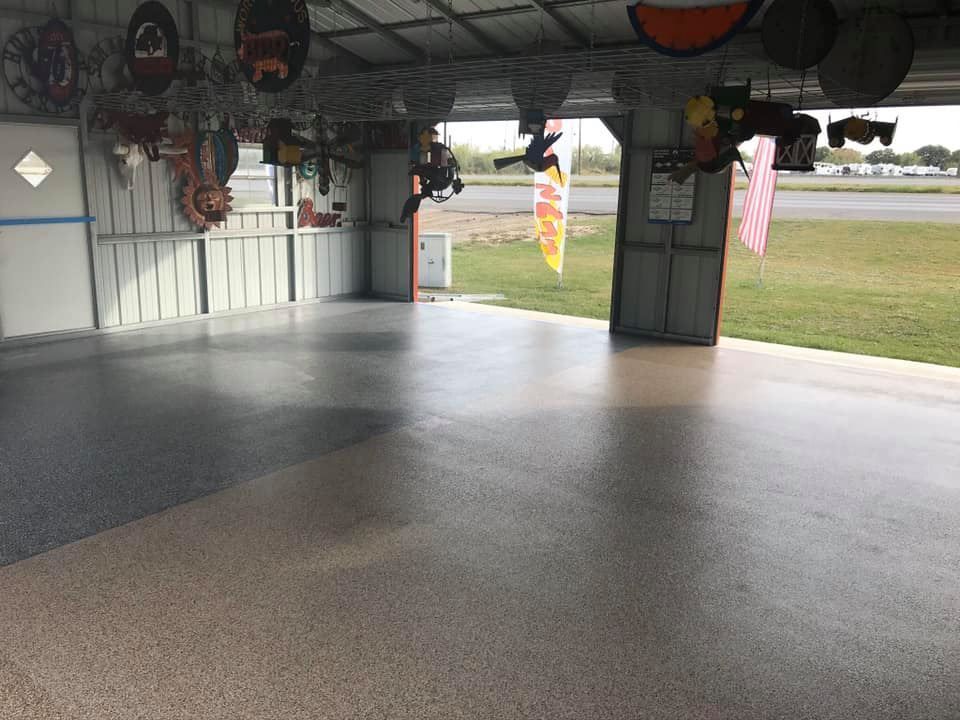 Epoxy-coated garage floor with various decorative items hanging from the ceiling. Outside view.