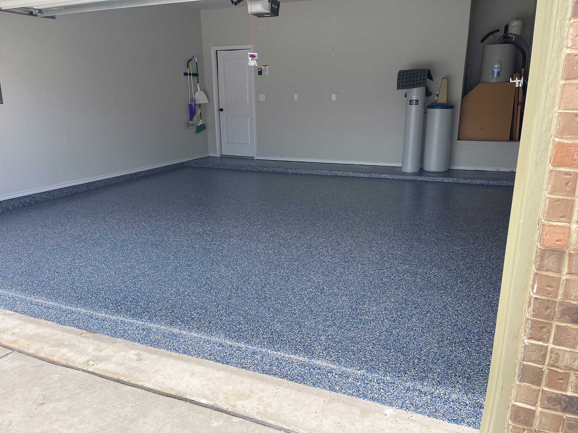 Garage with blue and gray speckled epoxy floor and light gray walls.