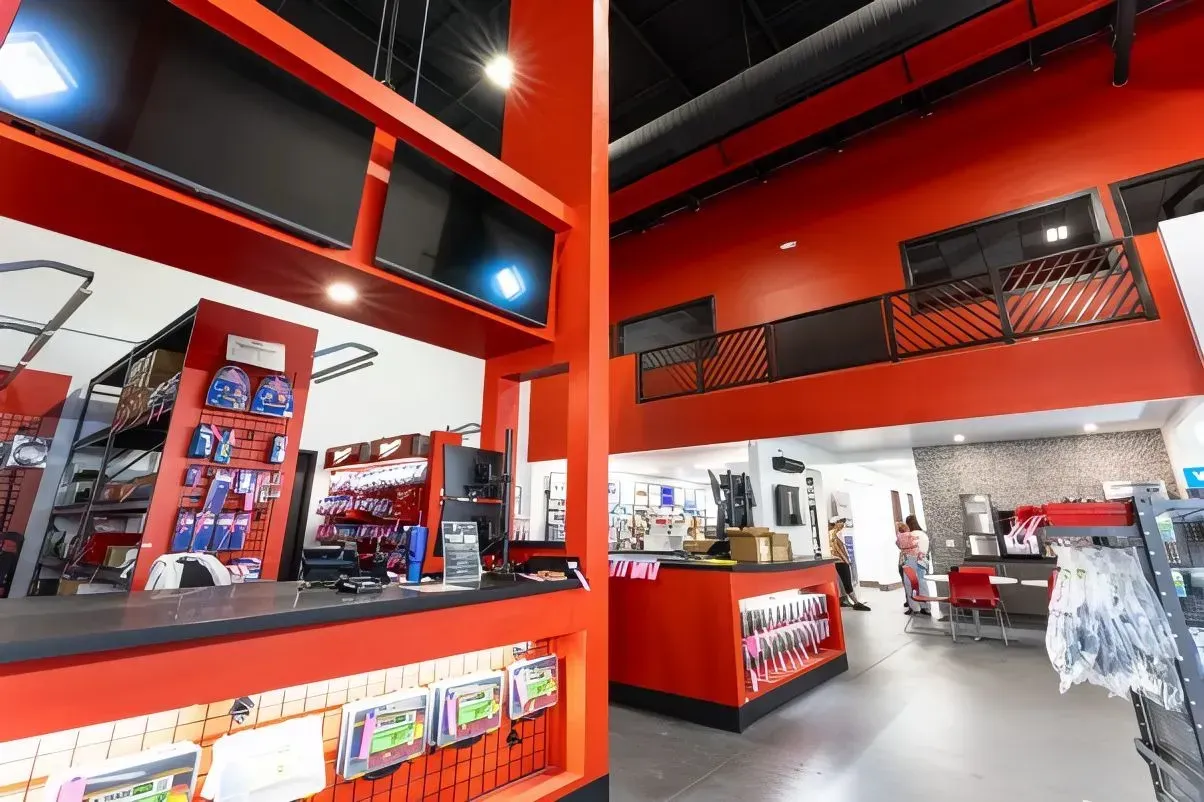Bright red retail store interior with checkouts, shelves, and a white tiled floor