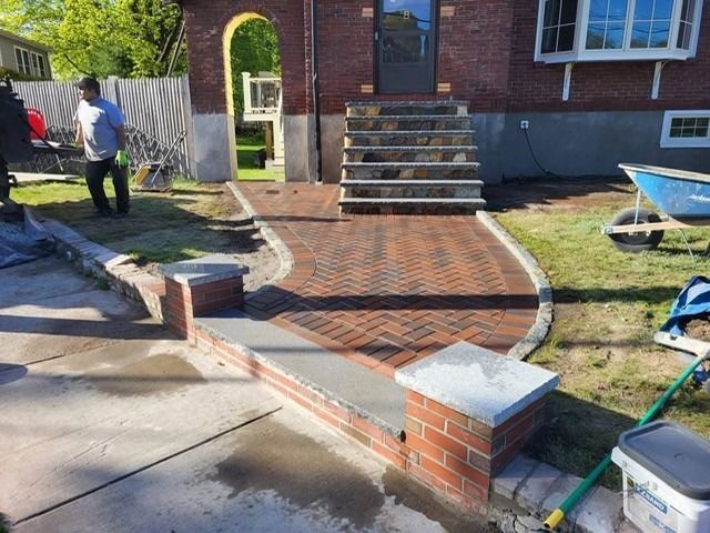 Red brick walkway leading to brick steps and front door of a house