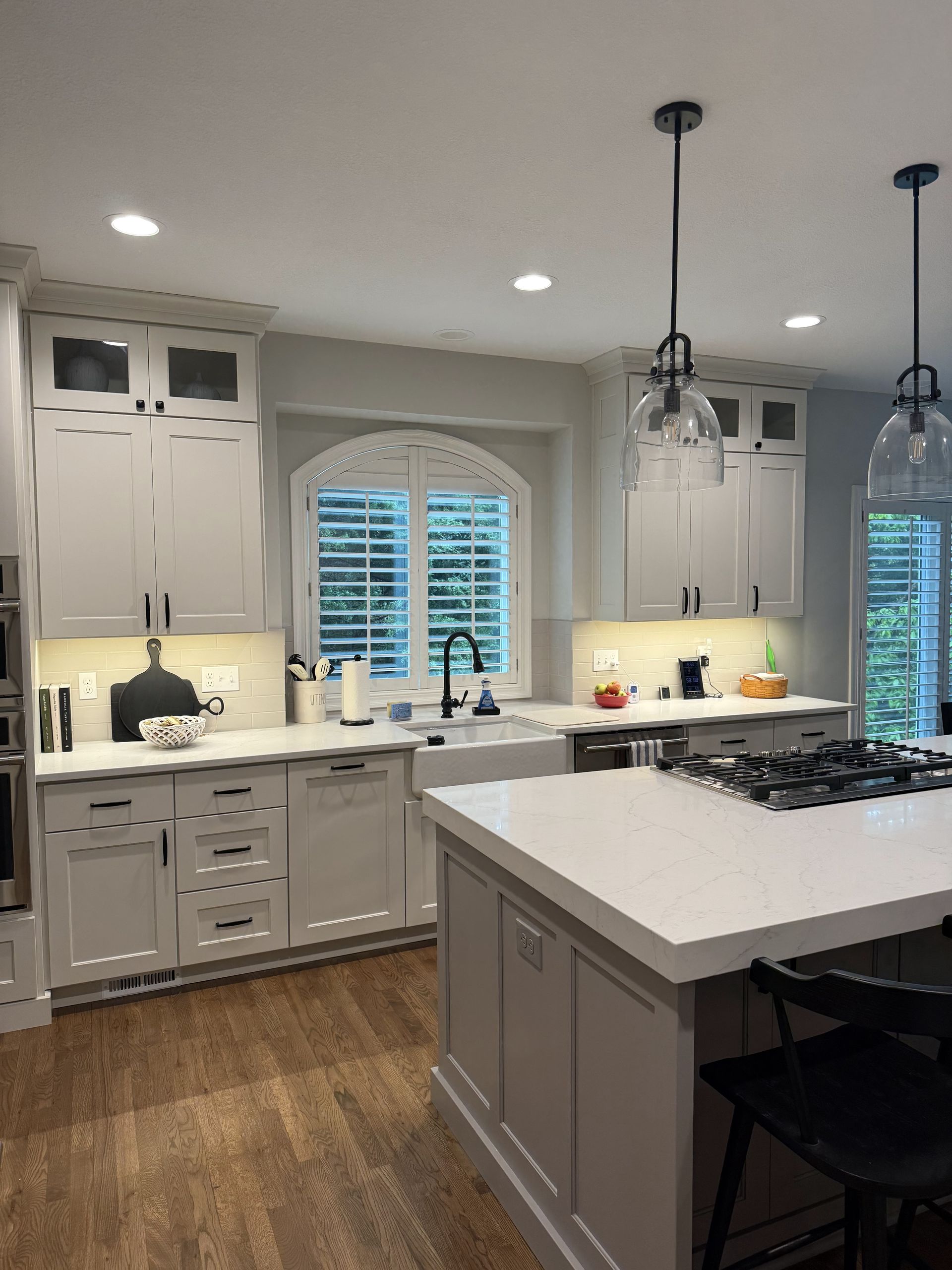 A kitchen with white cabinets and a large island
