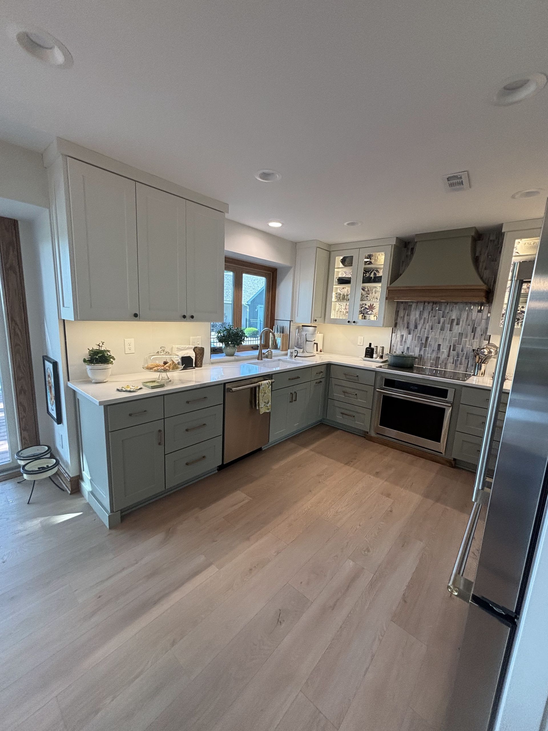 A kitchen with stainless steel appliances and white cabinets.