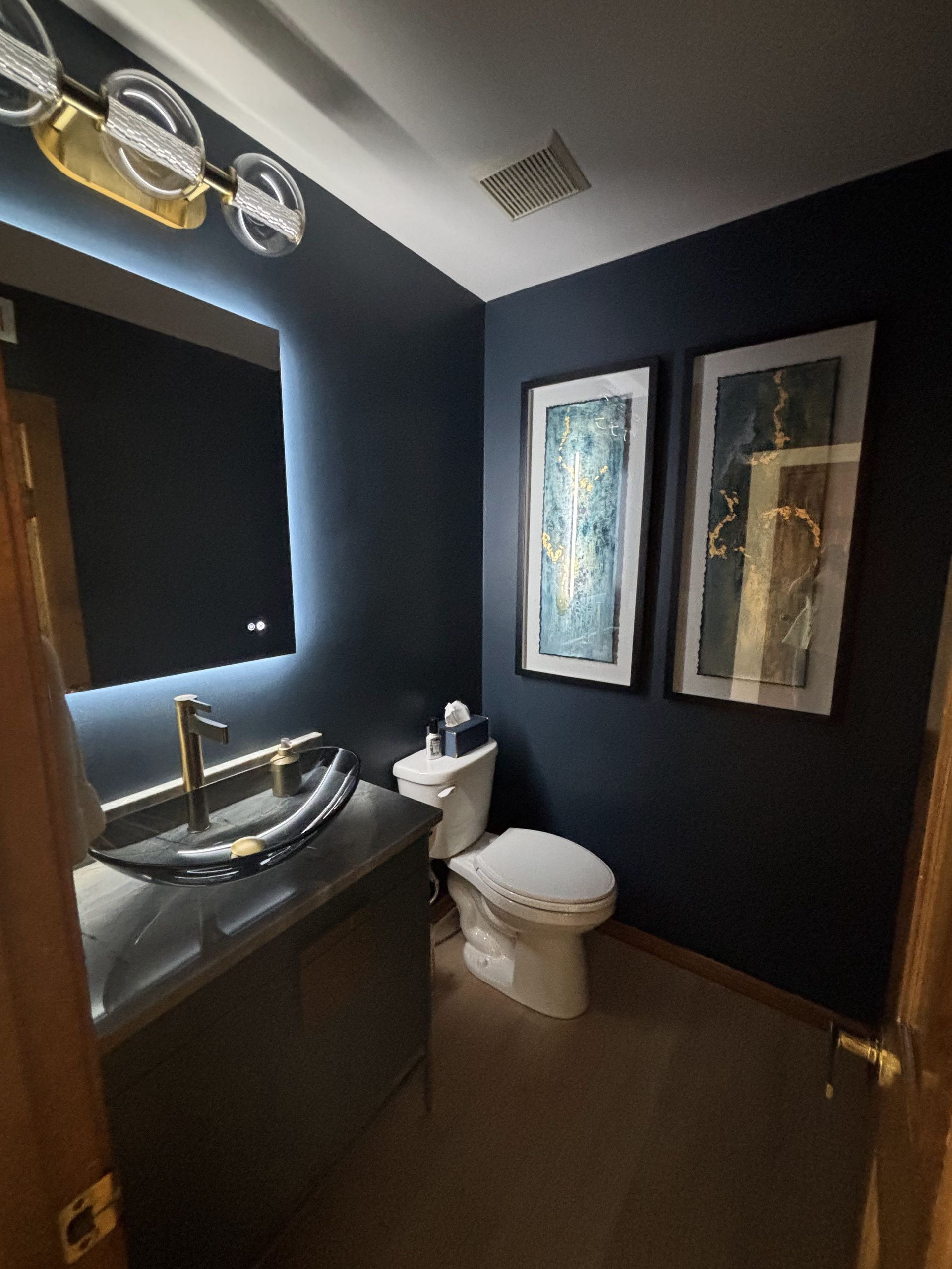 A bathroom with a toilet, sink and mirror