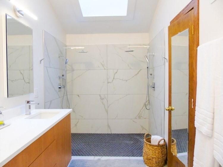 A bathroom with two sinks and a walk-in shower.