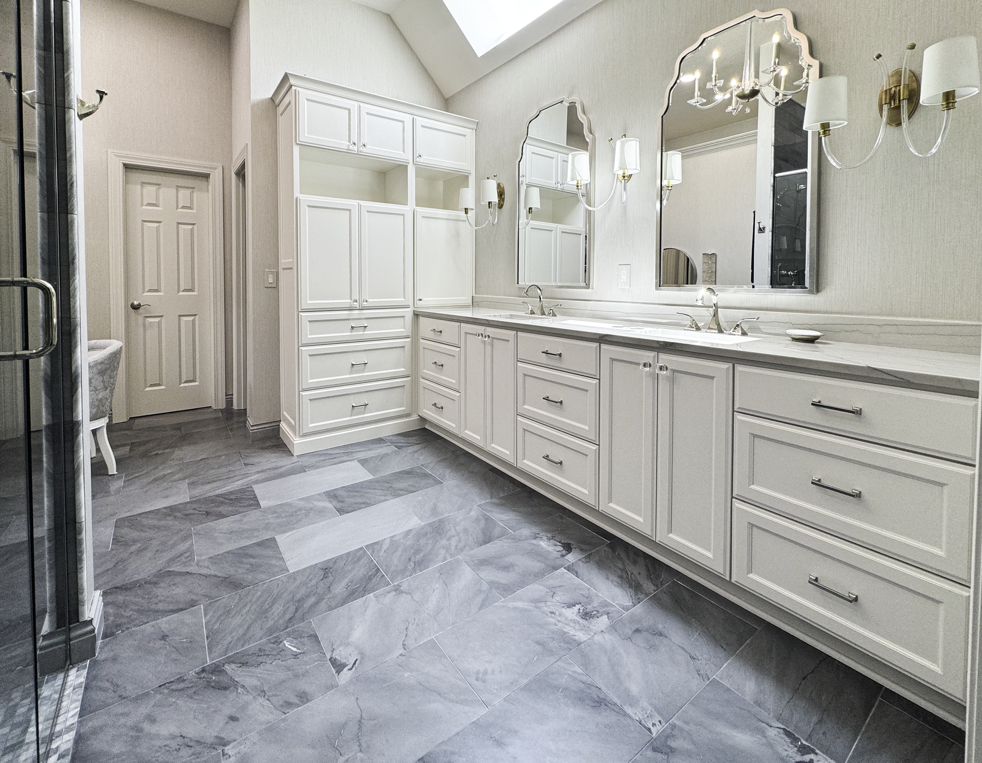 A bathroom with two sinks, two mirrors, and a walk-in shower.