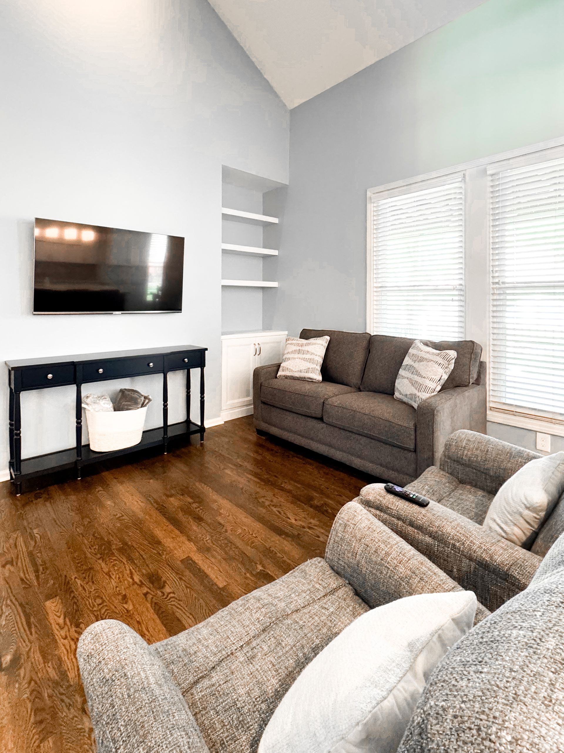 A living room with a couch, chairs, and a flat-screen TV.