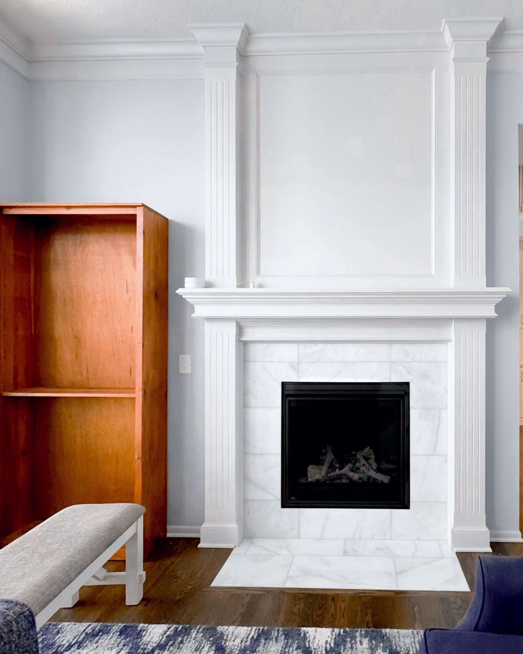 A living room with a fireplace and a bench.