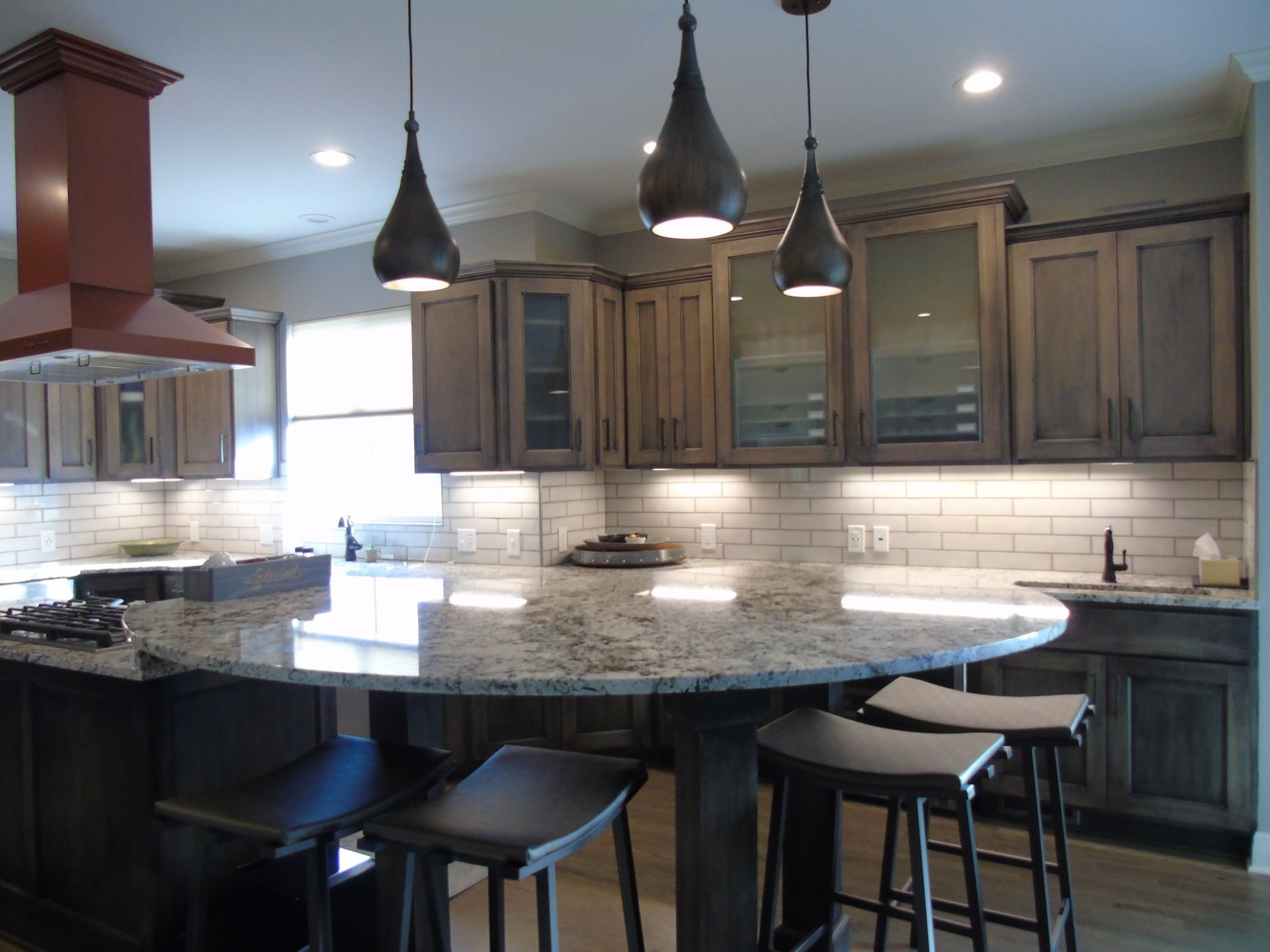 A kitchen with a large island and stools.