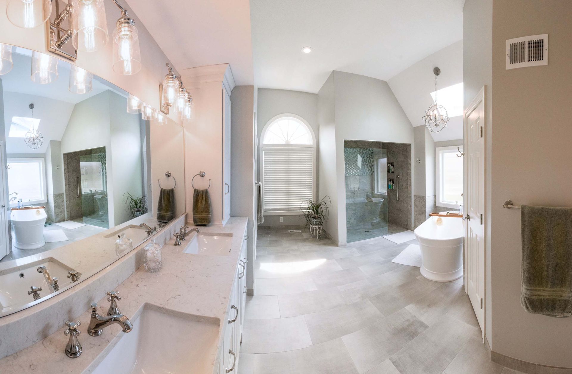 A bathroom with two sinks, a tub, and a large mirror.