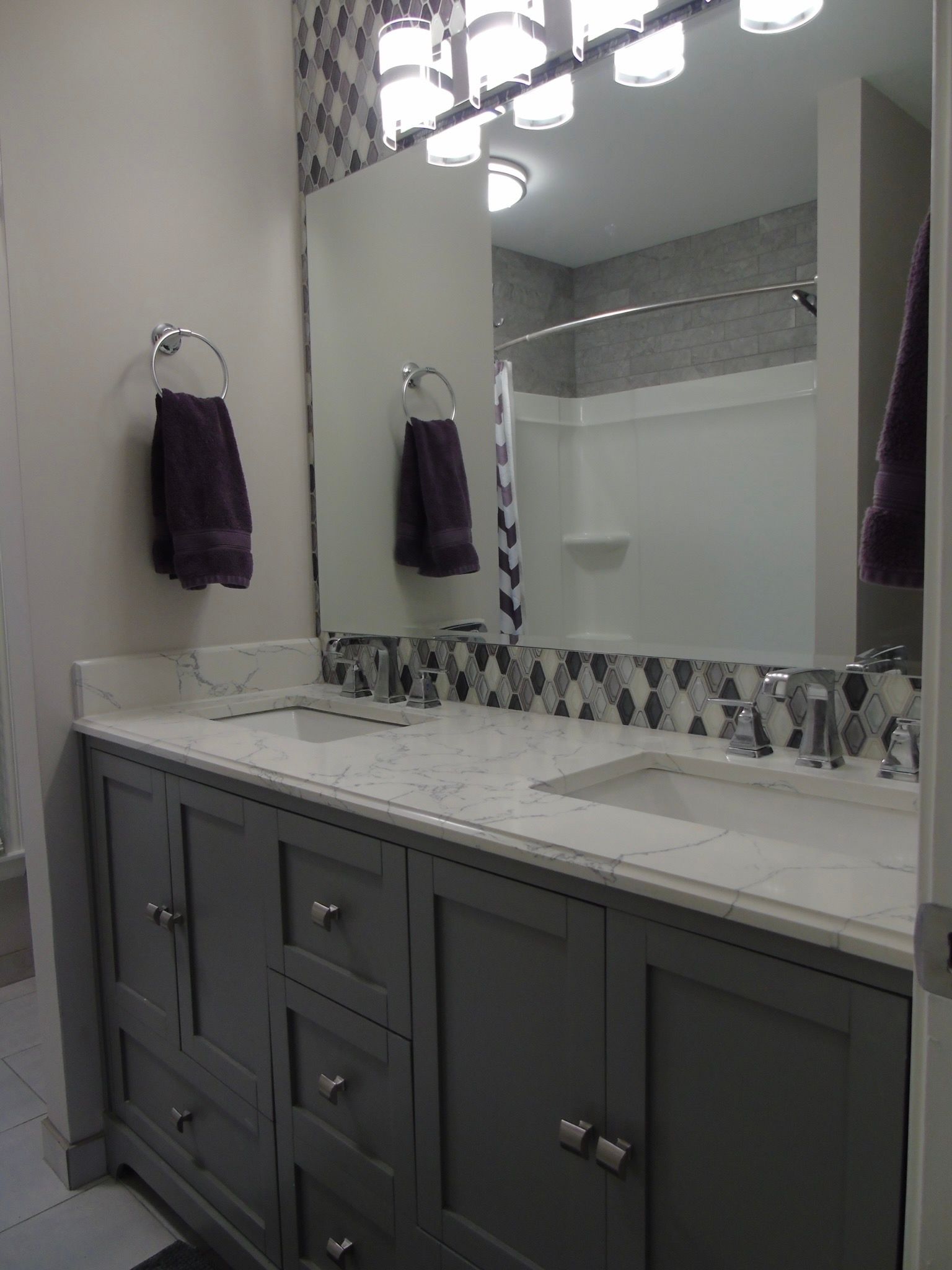 A bathroom with two sinks and a large mirror.