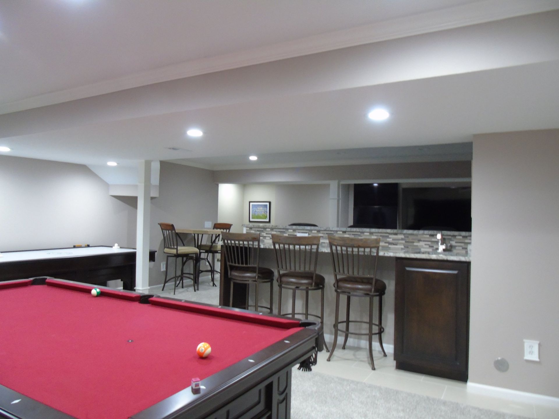 A pool table with a ball on it in a basement