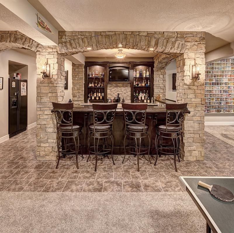 A bar with stools and a table in a basement