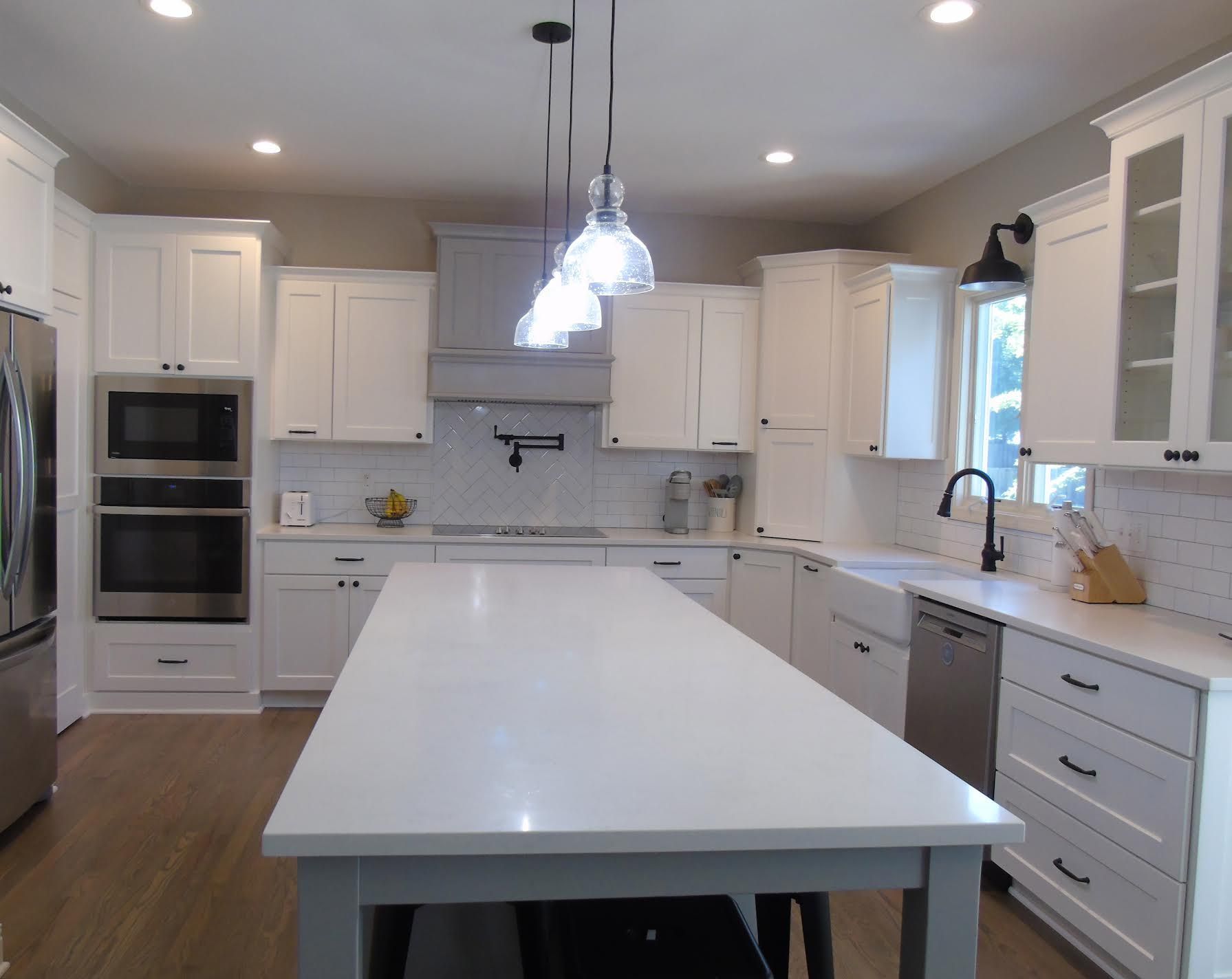 White kitchen with large island and stainless steel appliances
