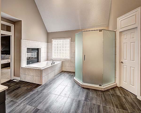 Spacious bathroom with a tub, shower, and window