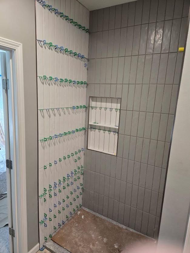 Bathroom with gray and white tile installation in progress