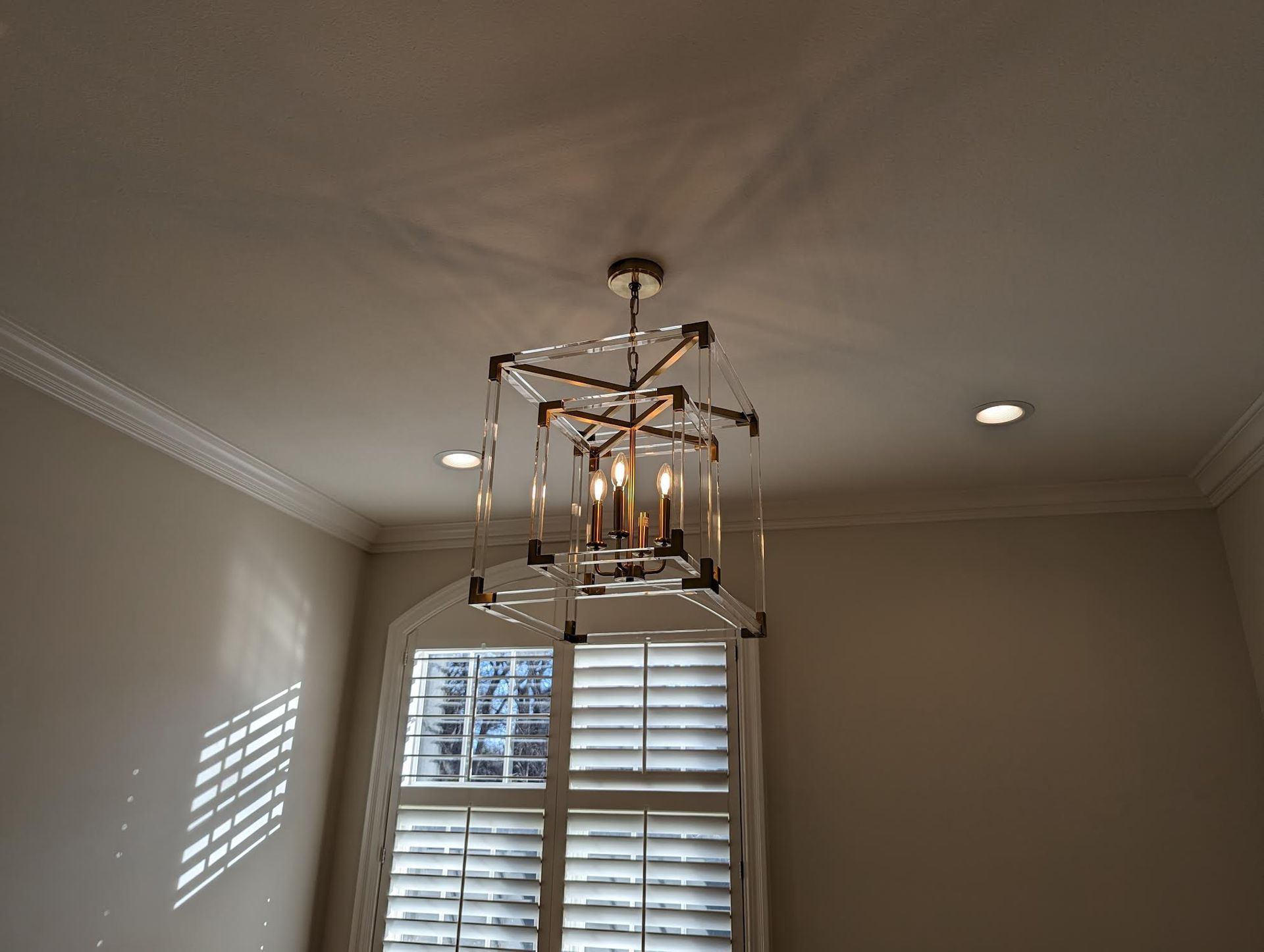 Modern geometric chandelier hanging from a white ceiling