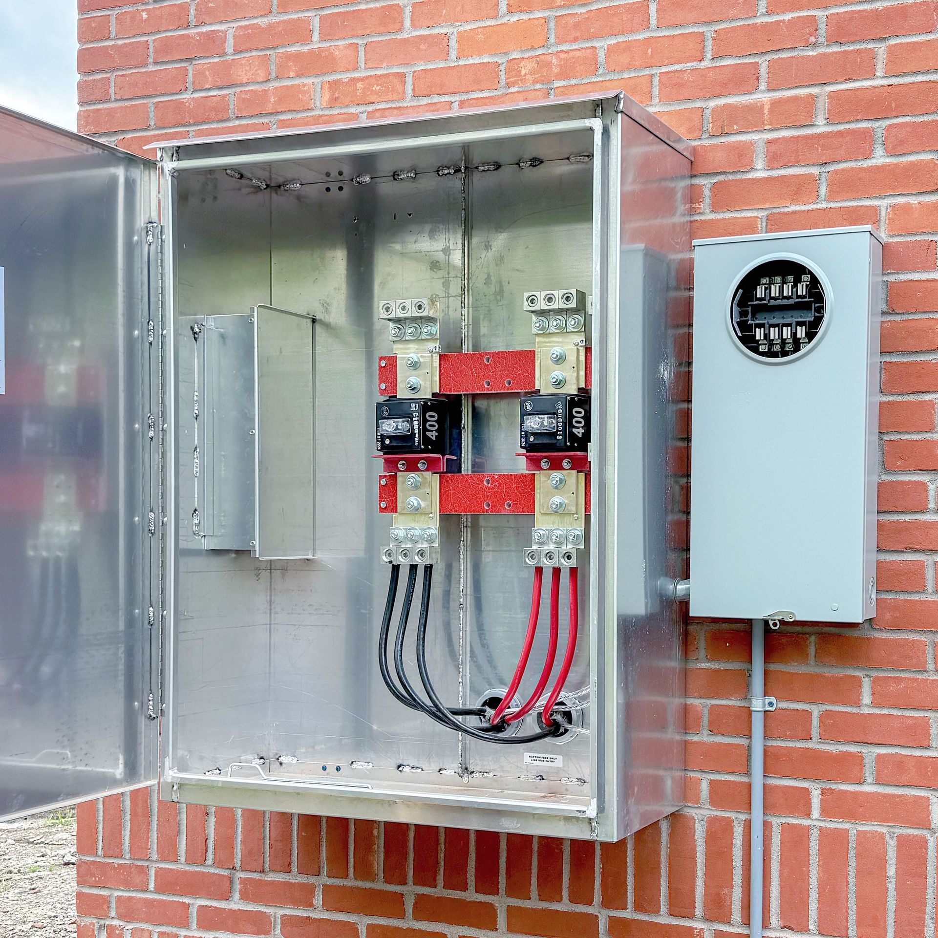Electrical service panel and meter box on a brick building