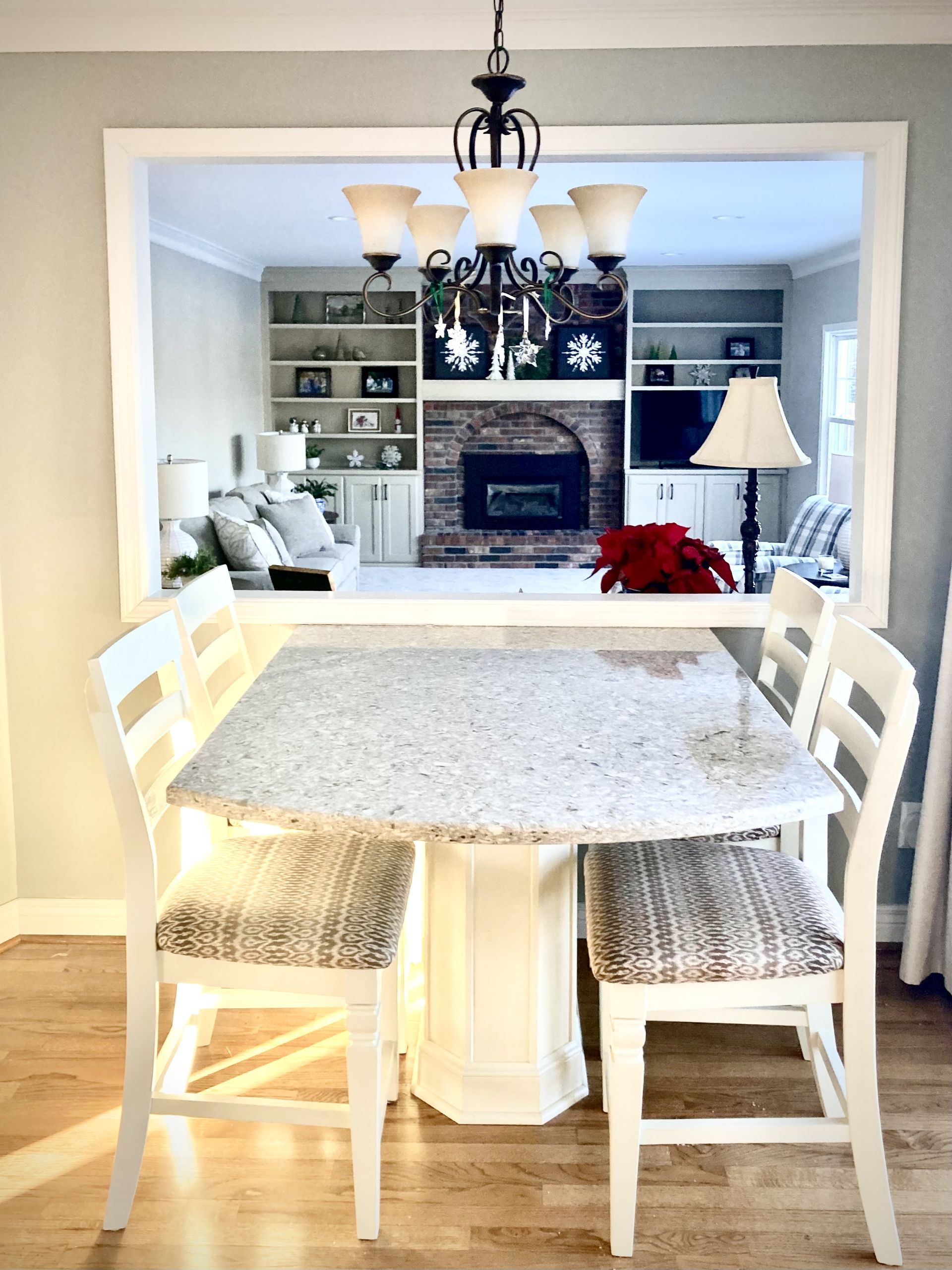 A dining room table and chairs with a fireplace in the background